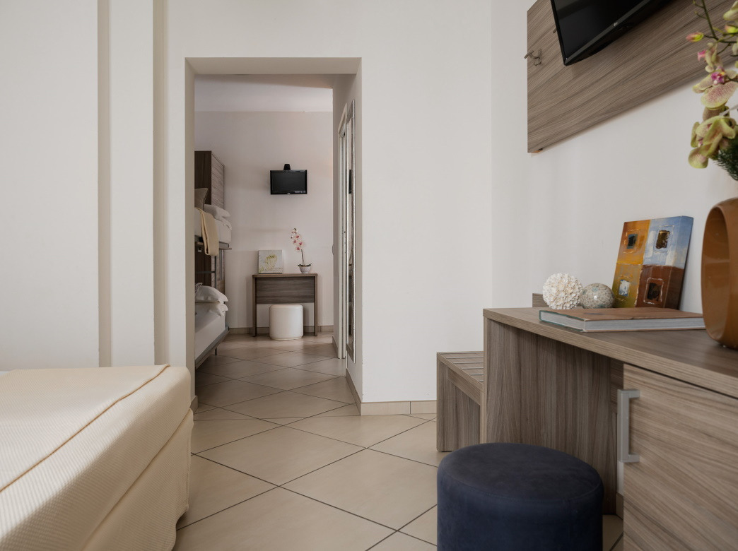 Camera moderna con letto, mobili in legno e decorazioni minimaliste.